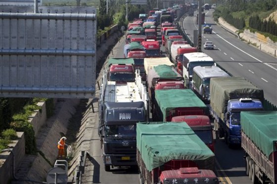 A cleaner picks up waste on the roadside of a jammed section of the Beijing-Zhangjiakou highway in Huailai in north China's Hebei province on Tuesday.
